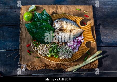 Traditionelle thailändische Essen: Gebratene Makrele serviert mit frischem Gemüse und Kraut, das Essen ist das thailändische Essen call Meuang Makrele (Maing-Pla-zu). Stockfoto