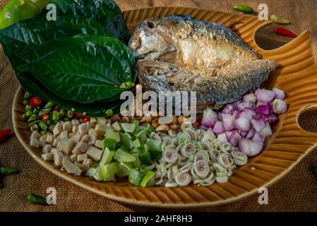 Traditionelle thailändische Essen: Gebratene Makrele serviert mit frischem Gemüse und Kraut, das Essen ist das thailändische Essen call Meuang Makrele (Maing-Pla-zu). Stockfoto