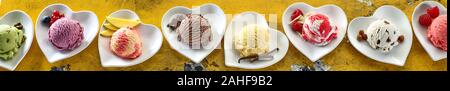 Breites panorama Banner mit verschiedenen Aromen von Eis in Kugeln auf Herz geformten Schüsseln serviert, die mit frischen Zutaten für eine Kopfzeile oder Werbung Stockfoto