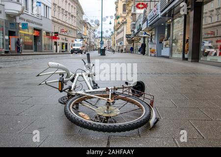 LINZ, ÖSTERREICH, 23.Dezember 2018, ist die beschädigte Fahrrad liegen auf der Straße im Zentrum der Stadt. Die abgerissen Fahrrad als Street Art - Leistung, Linz Stockfoto