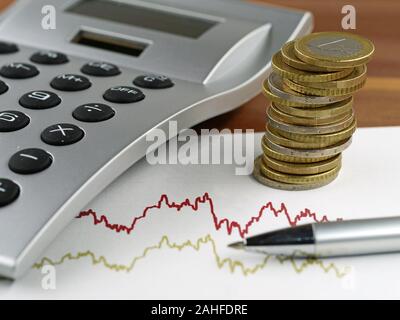 Nahaufnahme, Stift und Taschenrechner auf dem Schreibtisch mit trading Chart und Stapel von Euro-Münzen Stockfoto