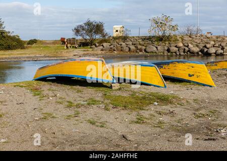 Gelbe Fischerboote liegen auf dem Sand am Fluss. Stockfoto