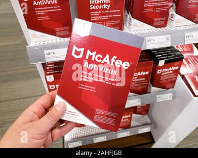 Montreal, Kanada - Dezember 26, 2019: eine Hand mit McAfee Antivirus, mit Lizenz und das Programm. McAfee ist eine US-amerikanische global Computer Sicherheit Stockfoto