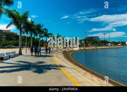 Luanda, angolanischer Zeit - 15. Dezember 2019: Menschen, die an einem sonnigen Tag in der Bucht von Luanda spazieren gehen. Redaktionelle Illustration. Stockfoto