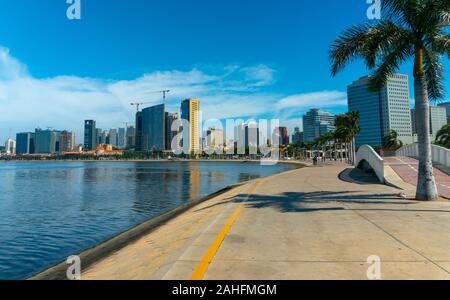 Luanda, angolanischer Zeit - 15. Dezember 2019: Menschen, die an einem sonnigen Tag in der Bucht von Luanda spazieren gehen. Redaktionelle Illustration. Stockfoto