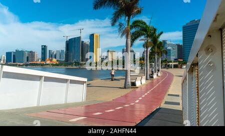 Luanda, angolanischer Zeit - 15. Dezember 2019: Menschen, die an einem sonnigen Tag in der Bucht von Luanda spazieren gehen. Redaktionelle Illustration. Stockfoto