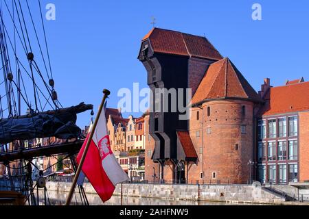 Alte Kran und bunte Hansestadt Fassaden der historischen Häusern, in der Nähe der Mottlau in Danzig, im Vordergrund ein traditionelles Segelboot ein Stockfoto