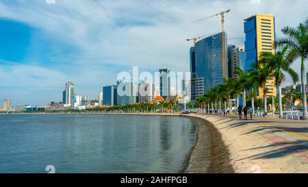 Luanda, angolanischer Zeit - 15. Dezember 2019: Menschen, die an einem sonnigen Tag in der Bucht von Luanda spazieren gehen. Redaktionelle Illustration. Stockfoto