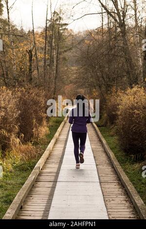 Frau Joggen entlang der Promenade in einer natürlichen Umgebung. Stockfoto