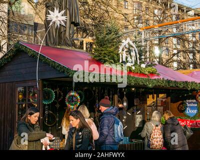 Die Princes Street Gardens, Edinburgh, Schottland, Vereinigtes Königreich. 29. Dezember 2019. Weihnachten feiern: Sonnenschein im Zentrum der Stadt mit einem Markt verkaufen bunt schillernden glitzernden Dekorationen zu Kunden Abschaltdruck Stockfoto