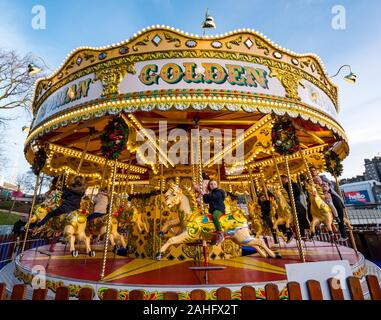 Die Princes Street Gardens, Edinburgh, Schottland, Vereinigtes Königreich. 29. Dezember 2019. Weihnachten feiern: Sonnenschein im Zentrum der Stadt mit Kindern geniessen eine Messe Fahrt auf ein altmodisches Karussell oder Merry-go-round Stockfoto