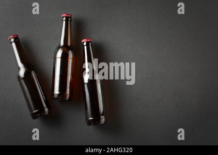 Drei Bierflaschen auf Schwarz konkreten Hintergrund mit kopieren. Stockfoto