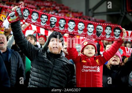 Liverpool Fans auf den Tribünen halten einen Schal zeigt die Gesichter der Spieler in der Premier League Spiel im Stadion Anfield, Liverpool. Stockfoto
