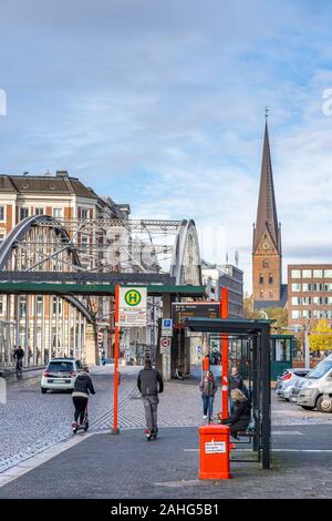 Hamburg, Deutschland - 9 November, 2019: die Menschen wartet bei St. Annen Bushaltestelle mit Petrikirch Kirche im Hintergrund Stockfoto