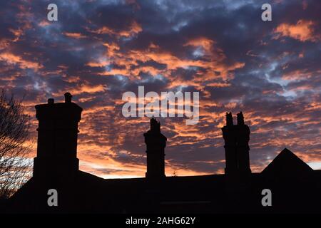 Urbaner Sonnenuntergang und Makrelenhimmel vor Schornsteintöpfen in England, Britatin, UK Kredit: David Bagnall Stockfoto