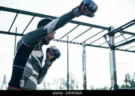 Ernsthafte Sportler die Faust im Boxhandschuh, die während der Ausbildung Stockfoto