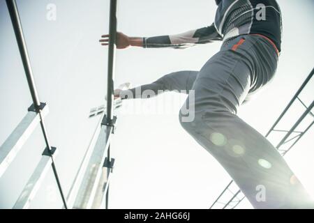 Ansicht von unten auf der Sportler seinen Fuß setzen auf das Chin Up Bar Stockfoto