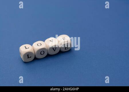 Liebe Wort Nachricht auf Holzklötze auf blauem Hintergrund geschrieben, Ansicht von oben. Stockfoto