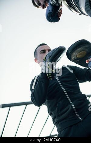 Taille bis schweren Mann mit Schwerpunkt Fausthandschuhe und Suchen konzentriert Stockfoto
