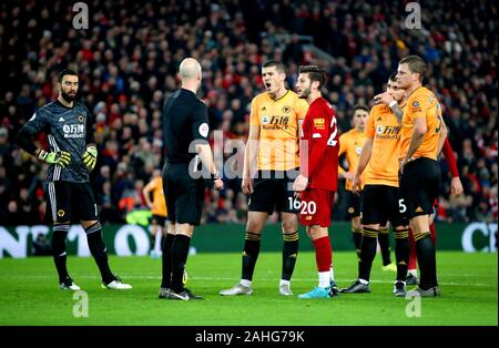 Wolverhampton Wanderers' Conor Coady (Mitte) und Liverpools Adam Lallana sprechen zu Schiedsrichter Anthony Taylor, wie sie die Entscheidung von VAR auf Ziel sadio's Mähne während der Premier League Spiel im Stadion Anfield, Liverpool erwarten. Stockfoto