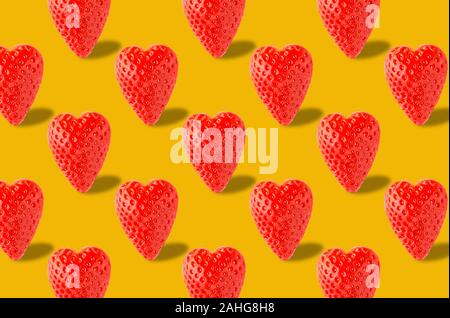 Erdbeere auf gelben Hintergrund. Beeren Muster. Rahmen aus frischen herzförmige Erdbeere auf weißem Hintergrund. Kreative essen Konzept. Stockfoto