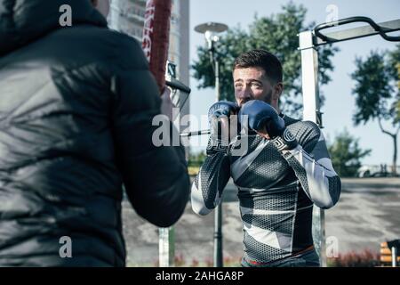 Ernsthafte MMA boxer Hände hoch, während des Trainings Stockfoto