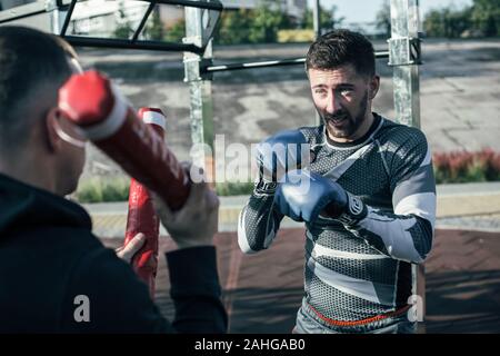 Bärtige Boxer runzelte die Stirn und auf die Boxen sticks Stockfoto