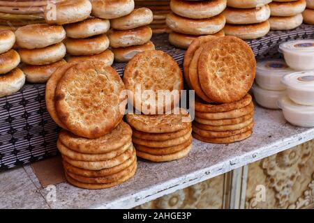 Traditionelle uigurische Fladenbrot zum Verkauf auf einem Markt in Kashgar. Die wichtigsten Zutaten Wasser, Mehl, Salz, Zucker, Hefe, Sesam & Öl. Stockfoto