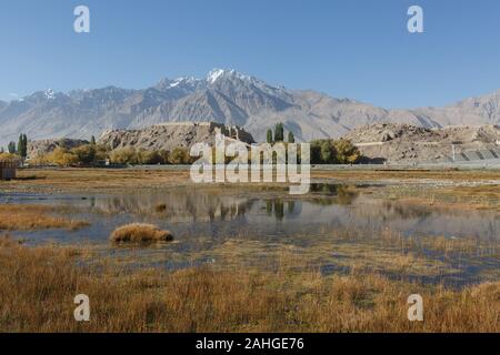 Blick auf Tashgurkan Stein Fort mit Pamir. Reflexionen der Stein Festung kann im Wasser im Vordergrund gesehen werden (Xinjiang, China) Stockfoto