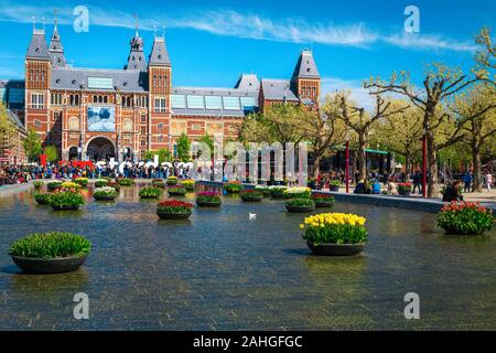 AMSTERDAM, NIEDERLANDE, 30. APRIL 2017: Staatliche Museen (Rijksmuseum) Gebäude, kleinen Teich mit bunten Blumen und IAMSTERDAM Worte eingerichtet Stockfoto