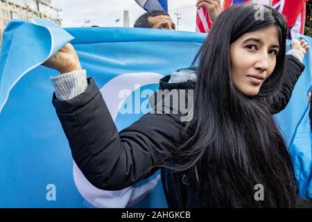 Amsterdam, Niederlande. 18 Mai, 2019. Eine weibliche Demonstrant Wellen ein nach Osten Turkmenistan Flagge während der Demonstration. Uiguren und Sympathisanten am Dam Square in Amsterdam sammeln ihre Unterstützung mit ethnischen Chinas Uiguren und Protest gegen das, was sie als die Unterdrückung der Uiguren in China von der Regierung dieses Landes zu zeigen. Credit: Niels Wenstedt/SOPA Images/ZUMA Draht/Alamy leben Nachrichten Stockfoto
