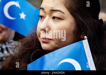 Amsterdam, Niederlande. 18 Mai, 2019. Hält eine Frau im Osten Turkmenistan Flaggen während der Demonstration. Uiguren und Sympathisanten am Dam Square in Amsterdam sammeln ihre Unterstützung mit ethnischen Chinas Uiguren und Protest gegen das, was sie als die Unterdrückung der Uiguren in China von der Regierung dieses Landes zu zeigen. Credit: Niels Wenstedt/SOPA Images/ZUMA Draht/Alamy leben Nachrichten Stockfoto