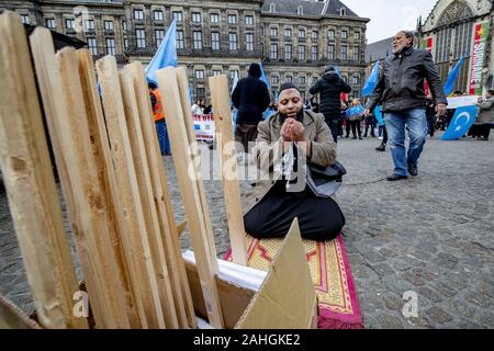 Amsterdam, Niederlande. 18 Mai, 2019. Muslimische Demonstranten führen Ihre 12.00 Uhr Gebet während einer Kundgebung. Uiguren und Sympathisanten sammeln am Dam Square in Amsterdam ihre Unterstützung mit ethnischen Chinas Uiguren und Protest gegen das, was sie als die Unterdrückung der Uiguren in China von der Regierung dieses Landes zu zeigen. Credit: Niels Wenstedt/SOPA Images/ZUMA Draht/Alamy leben Nachrichten Stockfoto