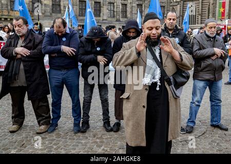 Amsterdam, Niederlande. 18 Mai, 2019. Muslimische Demonstranten führen Ihre 12.00 Uhr Gebet während einer Kundgebung. Uiguren und Sympathisanten sammeln am Dam Square in Amsterdam ihre Unterstützung mit ethnischen Chinas Uiguren und Protest gegen das, was sie als die Unterdrückung der Uiguren in China von der Regierung dieses Landes zu zeigen. Credit: Niels Wenstedt/SOPA Images/ZUMA Draht/Alamy leben Nachrichten Stockfoto