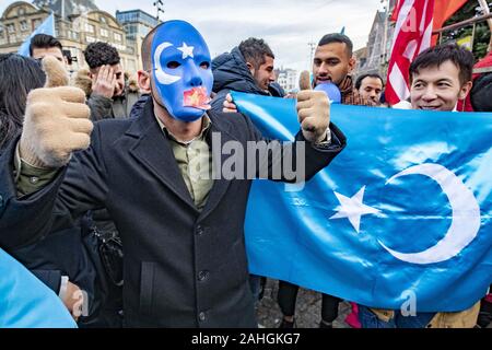 Amsterdam, Niederlande. 18 Mai, 2019. Eine Demonstrantin mit einer Maske nimmt Teil während der Demonstration. Uiguren und Sympathisanten am Dam Square in Amsterdam sammeln ihre Unterstützung mit ethnischen Chinas Uiguren und Protest gegen das, was sie als die Unterdrückung der Uiguren in China von der Regierung dieses Landes zu zeigen. Credit: Niels Wenstedt/SOPA Images/ZUMA Draht/Alamy leben Nachrichten Stockfoto
