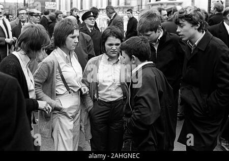 70er Jahre Teenager Mode Bovver Girls UK. Fußballunterstützungen versammeln sich vor dem Chelsea Football Club für ein Spiel gegen Queens Park Rangers. Drei junge Mädchen mit Jungen, die Mädchen sind in der Mode der Zeit als Bovver Girls gekleidet. Sie tragen Kleidung, die Jungen Kleidung imitieren, hoch taillierte Hosen, Jungen Hemden und Hosenträger. London England. 70ER JAHRE UK HOMER SYKES Stockfoto