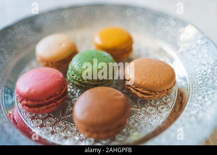 Traditionelle französische bunte Macarons auf dem Teller auf dem Tisch Stockfoto