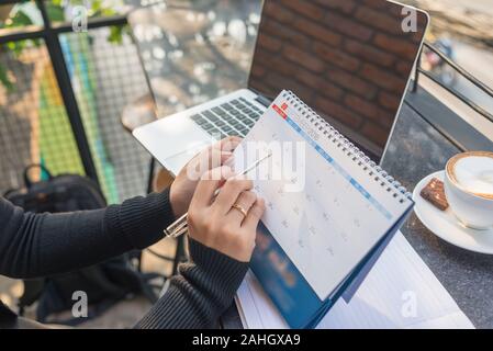 Die Frau in der Hand tragen Kalender und zeigen Sie ihm durch Pen Stockfoto