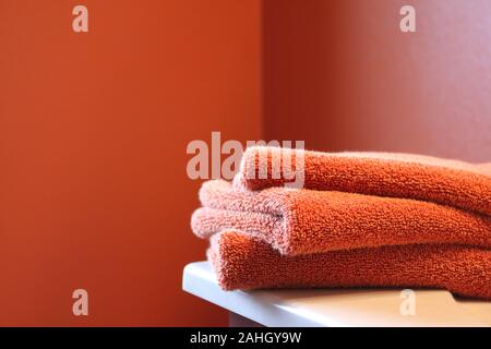 Stapel von Bettwäsche in Orange Badezimmer Stockfoto