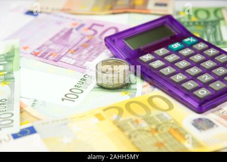 Ein Taschenrechner und Euro-Banknoten und -Münzen Stockfoto