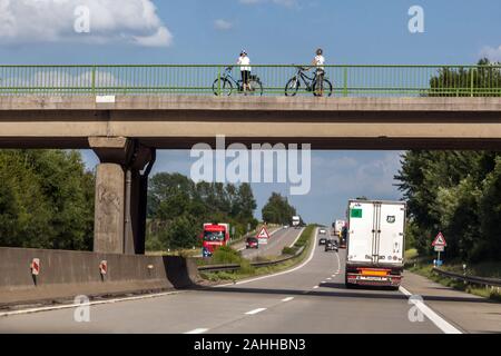 Menschen, zwei Bikerinnen auf der Brücke über die deutsche Autobahn Deutschland Active Lifestyle Radtour, Radfahren auf der Straße Stockfoto