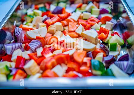 Close Up und selektiven Fokus der mediterranen Gemüse in einer Edelstahl Backblech auf weißem Marmor Hintergrund Stockfoto