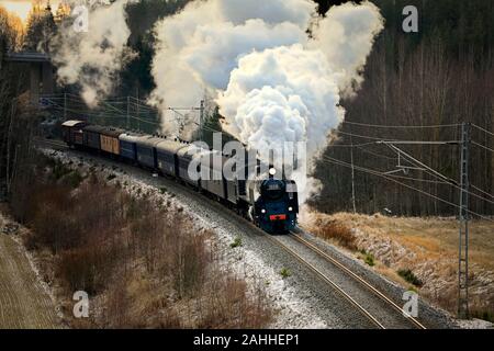 VR Hr1-Klasse Dampflok Ukko-Pekka 1009 ziehen Wagen an einem Wintermorgen durch ländliche Landschaft südlich von Salo, Finnland. 27. Dezember 2019. Stockfoto