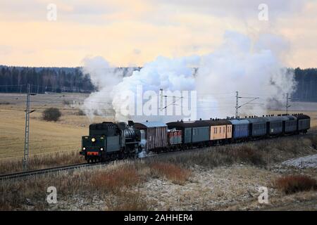 VR Hr1-Klasse Dampflok Ukko-Pekka 1009 ziehen Wagen an einem Wintermorgen durch ländliche Landschaft in Hajala, Salo, Finnland. 27. Dezember 2019. Stockfoto