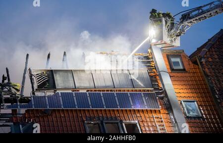 Barsinghausen, Deutschland. 30 Dez, 2019. Feuerwehrmänner ein großes Feuer löschen im Seminarhaus Ökostation Deister-Vorland in Großgoltern in der Region Hannover. Ein Feuer war im ehemaligen Bauernhaus am Morgen, das schnell auf den gesamten Dachstuhl ausgebreitet. Credit: Julian Stratenschulte/dpa/Alamy leben Nachrichten Stockfoto