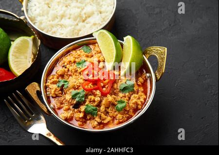 Huhn keema in der traditionellen indischen Kupfer kadai an dunklen Schiefer Hintergrund. Kheema ist die indische und pakistanische Küche Teller curry mit Hackfleisch und spic Stockfoto