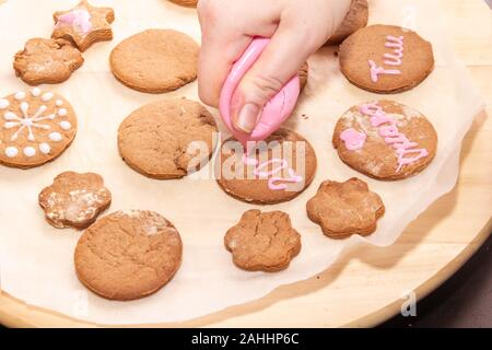 Backen holiday Cookies. Hände Lebkuchen verzieren. Christus. Weihnachten und neues Jahr Stockfoto