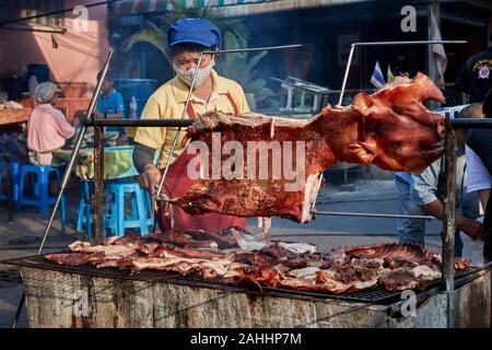 Schweinebraten mit Frau Kochen bei einem Street Food Markt und Food Festival, Na Klua Food Festival, Pattaya, Thailand, Hog roast Stockfoto