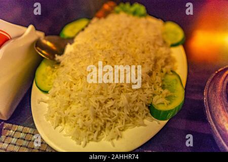 Traditionelle köstlichen Pakistanischen Haufen Reis serviert auf einem weißen Teller mit Gurke Stockfoto