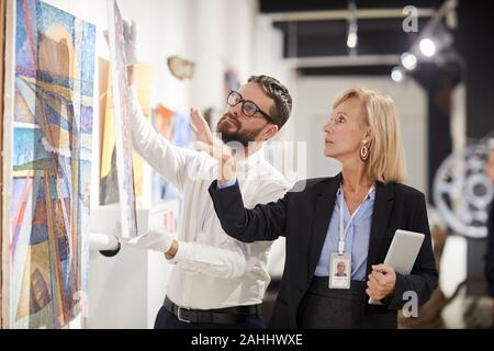 Taille bis Portrait der weiblichen Art gallery Manager hängen Gemälde beim Organisieren, Ausstellung im Museum, Kopie Raum Stockfoto